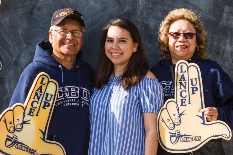 A female CBU student posing with her grandparents at an event